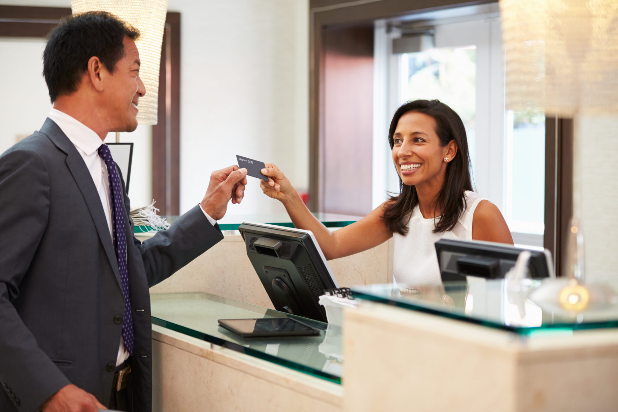 Businessman Checking In At Hotel Reception Front Desk